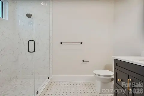 Main level guest ensuite with shower thoughtfully framed to a 10' ceiling height to help retain warmth and steam, with a transom window bringing in natural light while maintaining privacy.