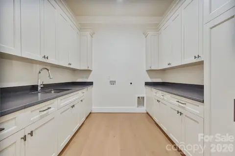 Spacious upstairs laundry room convenient to bedrooms featuring abundant custom cabinetry and storage, thoughtfully finished with a soft-close cavity pocket door for a clean, seamless look. Tons of storage.