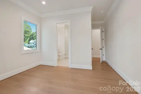 Bedroom 3 is filled with natural light from expansive windows and features a spacious walk-in closet, combining comfort with generous storage.