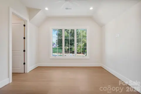 Bedroom 4 features large windows for abundant natural light, a spacious walk-in closet, and convenient access to additional attic storage.