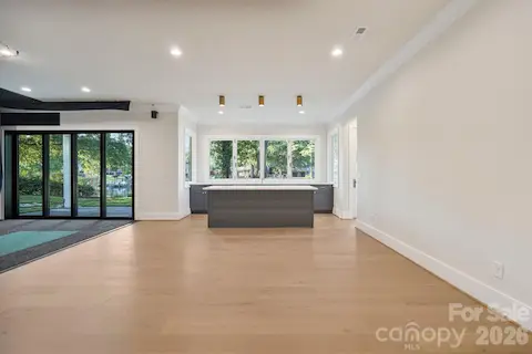 Luxury basement kitchenette featuring a built-in wine cooler and ice maker, plus an accordion-style window that opens directly to the outdoor living space for seamless indoor-outdoor entertaining.