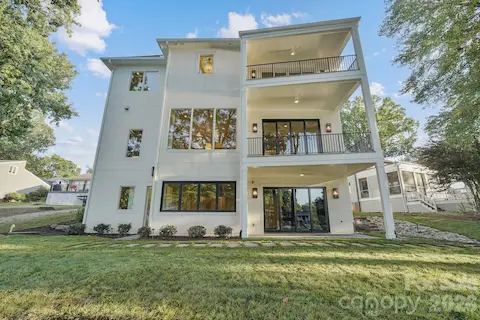 Stunning rear elevation showcasing expansive windows and multiple porches designed to maximize natural light and outdoor living.