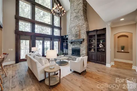 Floor-to-ceiling stone fireplace, custom built-ins and soaring windows define the great room