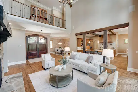 Exposed wood beams frame the open connection between the great room and chef’s kitchen