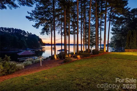 Sunrise over Lake Norman, framed by mature pines and beautifully lit waterfront landscaping