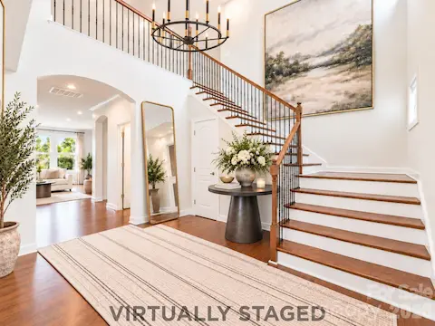 Virtually staged, the soaring foyer reveals its potential as an elegant introduction to the home, where thoughtfully placed furnishings complement the graceful staircase and create a warm, memorable sense of arrival.