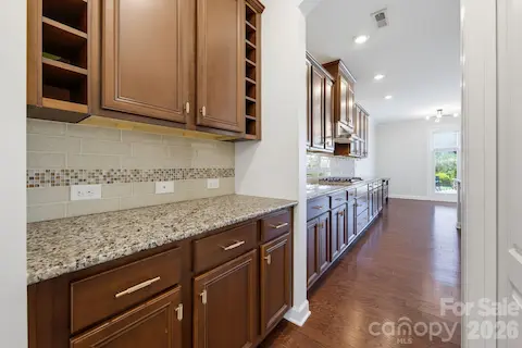 Extra cabinetry and counter space in the butler's pantry, complete with a spacious walk-in pantry closet, between the kitchen and formal dining room extend the kitchen's storage and serving capacity, ideal for a coffee station or entertaining setup.
