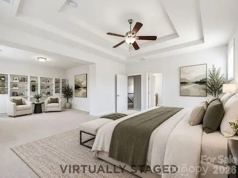 Virtually staged to showcase the suite's scale, the primary bedroom opens naturally into a private lounge ready for reading, relaxing, or quiet morning coffee, which overlooks the beautiful pergola and fire pit in the expansive backyard