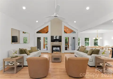 A vaulted ceiling, fireplace, and generous windows bring light and character to the great room, with doors opening to the covered porch.