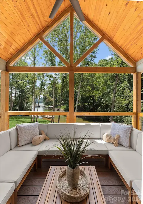 Settle in beneath the vaulted wood ceiling and enjoy a view through the trees to the dock and water.