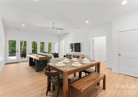 The open layout connects the dining area and lounge, with doors leading outside to the backyard.