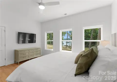 From this bedroom, enjoy a glimpse of the lake through the trees.