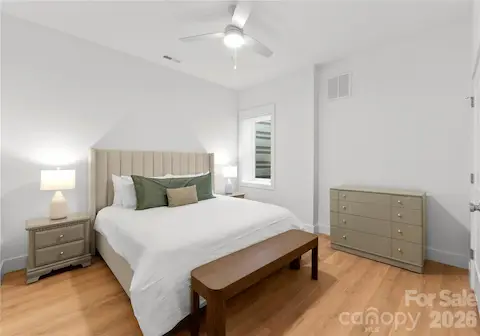 Soft neutral finishes and warm wood floors make this bedroom a restful place to unwind after a day on the lake