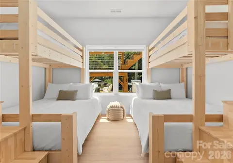 Two custom-style bunk beds create a welcoming space for a houseful of guests, with a window overlooking the outdoor living area.
