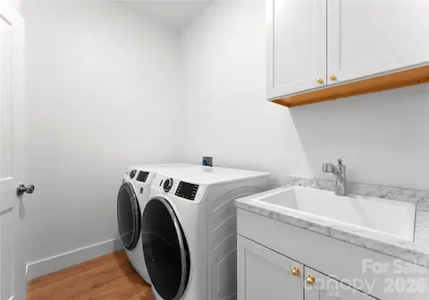 A second laundry area with a utility sink and overhead cabinets makes everyday living and guest turnovers more convenient.