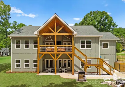 A striking timber-framed porch anchors the rear of the home, offering covered outdoor space on both levels.