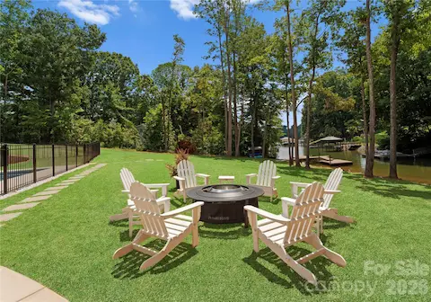 Gather around the fire pit under the trees, with the lake and dock in view.