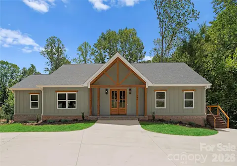 Timber accents and welcoming double doors give the home a warm first impression, while the broad driveway offers ample arrival space.